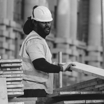 A construction worker at a construction site dealing with wage inequalities.