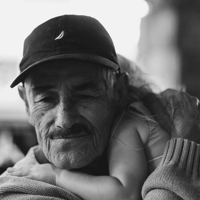 A man holding a child seeking an opportunity out of poverty.