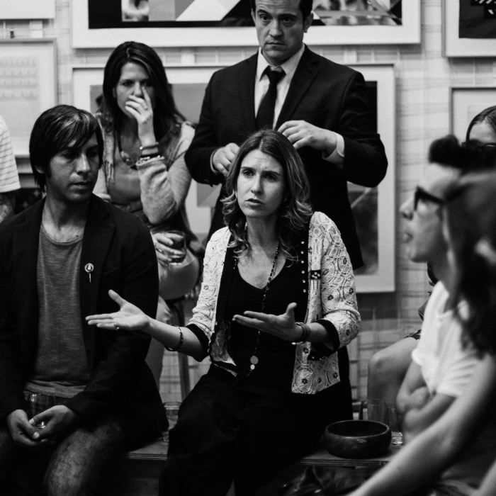 A woman speaking in front of a group debating how to limit poverty and create opportunities for everyone in California.