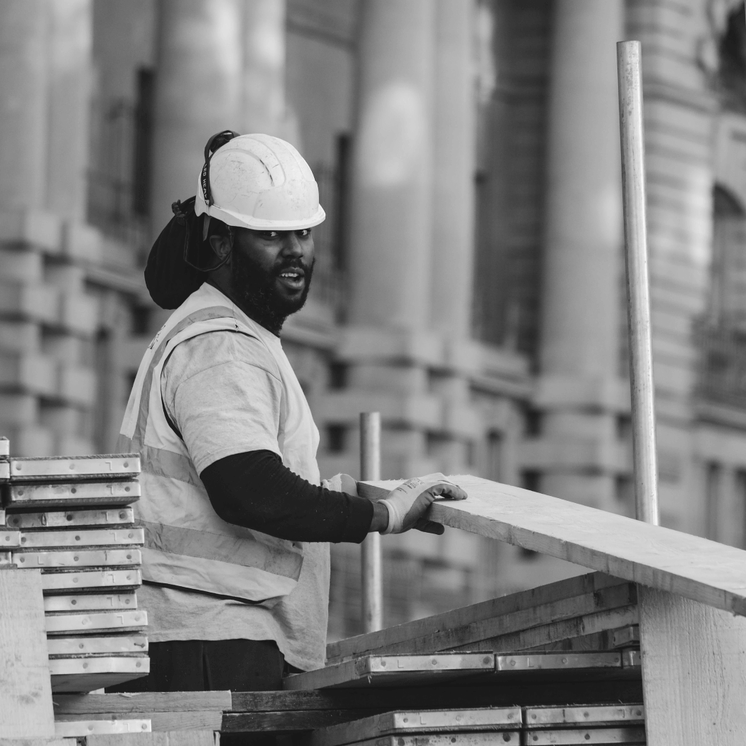 A construction worker at a construction site smiling at the camera